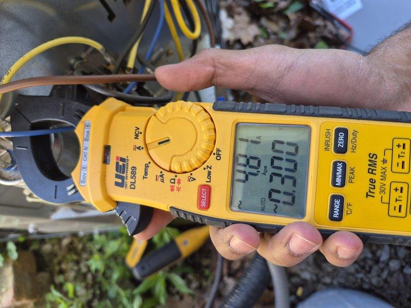 Responded to callback for recurring system failure following circuit board replacement from previous week. Upon arrival, confirmed air conditioning and heating system were both non-operational. Performed diagnostic testing using clamp meter to measure electrical current and voltage at outdoor condensing unit. Readings indicated abnormal amperage draws and potential electrical supply issues affecting both AC and furnace operation. Documented equipment conditions and electrical measurements with photos showing 26.9 and 39.63 amp readings at condenser unit. Further troubleshooting required to identify root cause of repeated system failures beyond previously replaced control board.