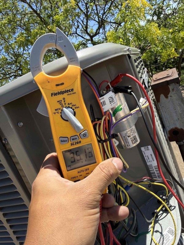 Completed comprehensive clean and check maintenance service on single HVAC system per comfort plan agreement. Performed electrical diagnostics using clamp meter to verify compressor amperage draw and system performance, recording readings of 35.73 amps and confirming proper operation within manufacturer specifications. Inspected all electrical connections, capacitor integrity, and control wiring throughout air handler and condensing unit, documenting system condition with photos for service records.