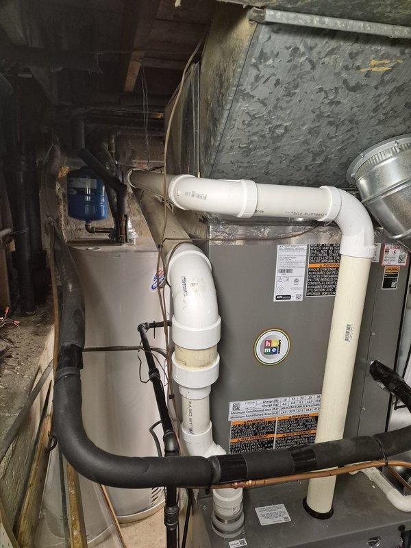 Completed callback to address multiple deficiencies from initial heat pump and furnace installation. Charged refrigerant system and enabled balance point settings on heat pump unit. Secured thermostat to wall with proper fasteners and trimmed/cleaned thermostat wire terminations. Outstanding items requiring follow-up visit include: installation of dehumidifier end panel, acoustic insulation for 10" rigid ductwork to reduce noise transmission, installation of discharge air sensor, and installation of combustion air intake pipe per manufacturer specifications.