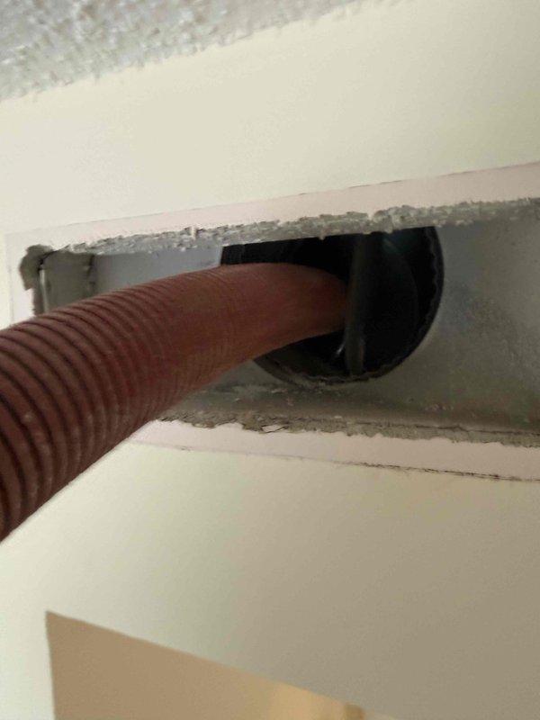 Completed comprehensive duct cleaning service for single-system HVAC installation in condominium unit. Accessed and cleaned flexible corrugated ducting through ceiling penetration points, removing accumulated dust and debris from ductwork. Documentation photos captured condition of duct access points and flexible ducting routing through structural openings.