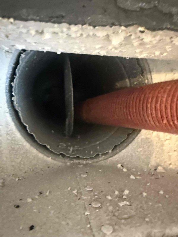 Completed comprehensive duct cleaning service for single-system HVAC installation in condominium unit. Accessed and cleaned flexible corrugated ducting through ceiling penetration points, removing accumulated dust and debris from ductwork. Documentation photos captured condition of duct access points and flexible ducting routing through structural openings.