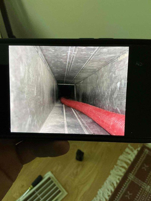 Completed comprehensive duct cleaning service for single-system condo unit, including thorough cleaning of main supply trunk lines and branch ducts. Accessed and cleaned rectangular main duct trunk showing accumulated dust and debris along interior surfaces, utilizing specialized rotary brush equipment and negative air pressure system with flexible extraction hose. Inspected and serviced round branch duct connections with damper mechanisms, removing built-up particulate matter from interior surfaces and damper blades to restore proper airflow and system efficiency.