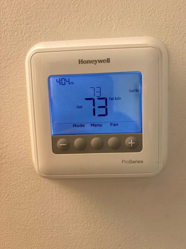 Responded to no cooling complaint on 6-year-old residential air conditioning system. Upon arrival, verified thermostat settings and confirmed Honeywell ProSeries programmable thermostat was properly set to cooling mode at 73 degrees with fan set to auto. Inspected outdoor condensing unit and found fan motor not operating consistently, with unit shutting off after restart attempts. Checked electrical connections, capacitor, and contactor operation. Examined refrigerant line insulation for proper coverage and condition. Verified air filter status and circuit breaker positions at electrical panel. Diagnosed intermittent fan motor failure causing system shutdown and loss of cooling capacity.