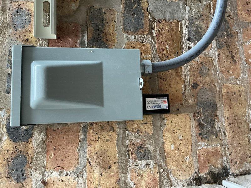 Completed no-charge callback to install surge protector on HVAC system mounted to exterior brick wall with deteriorated mortar. Installed gray electrical enclosure with conduit routing and verified proper wiring connections to equipment. Extended PVC flue piping using two couplings, two long sweep 90-degree elbows, and two street 45-degree fittings per specifications. Documented installation with photos showing completed surge protection device, electrical box mounting, and existing line set with insulation.