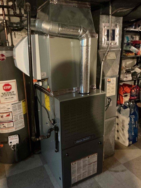 # HVAC Maintenance - Comfort Plan Clean and Check 1 System

Completed spring preventive maintenance inspection on residential split system consisting of American Standard furnace and outdoor condensing unit per comfort plan agreement. Performed comprehensive electrical diagnostics on outdoor unit using clamp meter to verify proper amperage draw and component operation. Inspected and tested capacitor, contactor, and all electrical connections within condensing unit, ensuring secure wire terminations and proper voltage readings. Verified outdoor unit airflow through condenser coil and checked refrigerant line insulation condition. Inspected indoor furnace unit in basement mechanical room, confirming proper labeling and general equipment condition. System operating within normal parameters with no immediate repairs required at time of service.