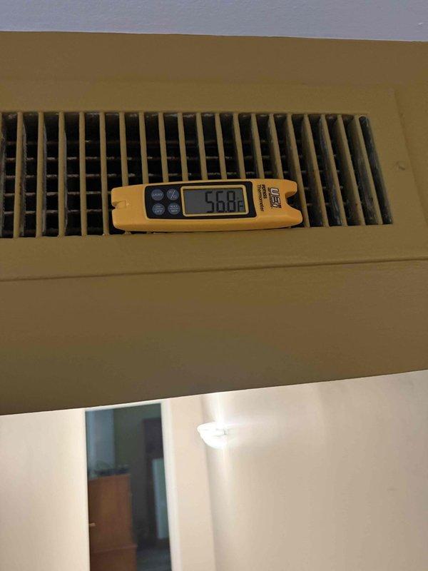 Responded to no cooling complaint with reported water leakage from air conditioning system. Upon inspection, discovered severely corroded copper refrigerant lines with significant deterioration and crusty buildup indicating long-term moisture exposure and potential refrigerant leak. System showed multiple signs of aging including oxidized copper piping with green verdigris formation and deteriorated insulation wrapping. Measured supply air temperature at floor register reading 50°F, confirming inadequate cooling performance. Documented extensive corrosion throughout refrigerant line assembly and deteriorated system components consistent with unit age exceeding 10 years. Photographed corroded refrigerant lines and recorded airflow measurements for diagnostic documentation.