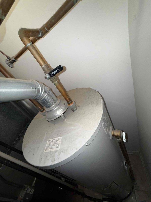 # Tanked Water Heater Leak Assessment

Responded to service call for leaking water heater at residential property. Upon arrival, confirmed water supply to tank had been shut off by occupant, with no active leaking present at time of inspection. Conducted thorough visual examination of water heater unit and surrounding plumbing connections. Inspected copper supply lines, flexible connectors, temperature and pressure relief valve, drain valve, and tank integrity for signs of moisture, corrosion, or failure points. Documented condition of unit and piping configuration with photographic evidence. Identified source of reported leak and provided assessment of water heater condition. Advised on necessary repairs or replacement options based on findings.
