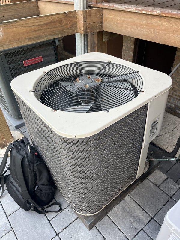 Conducted comprehensive site assessment for complete air conditioning system replacement at residential property. Evaluated existing outdoor condenser units, including aging cylindrical unit positioned beneath elevated deck structure on paver patio and secondary unit on rooftop platform. Documented current equipment configuration, installation locations, and spatial constraints for replacement planning. Assessed deck clearances, accessibility for future service, and structural considerations for proper equipment placement. Photographed existing HVAC equipment conditions, mounting surfaces, and surrounding infrastructure to develop accurate replacement specifications and equipment recommendations for customer consideration of both AC and potential furnace system upgrades.