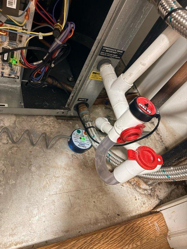 Installed wet switch on floor in front of heat pump unit to kill power when tripped, providing overflow protection for the system. Added float switch with T-fitting at humidifier drain line connection to shut down humidifier power in the event of drainage issues, preventing potential water damage to the mechanical closet and equipment.