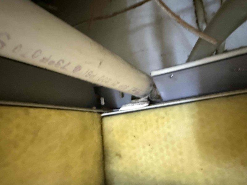 Responded to emergency water leak call at commercial property. Upon arrival, inspected HVAC equipment and associated plumbing infrastructure in mechanical space. Located source of water leak in vicinity of PVC piping and ductwork system. Documented existing conditions with photographs showing overhead utility space with horizontal PVC pipe runs, fiberglass insulation, metallic ductwork, and associated mechanical components. Assessed situation and contacted office to report findings and initiate approval process with property management for necessary repairs.