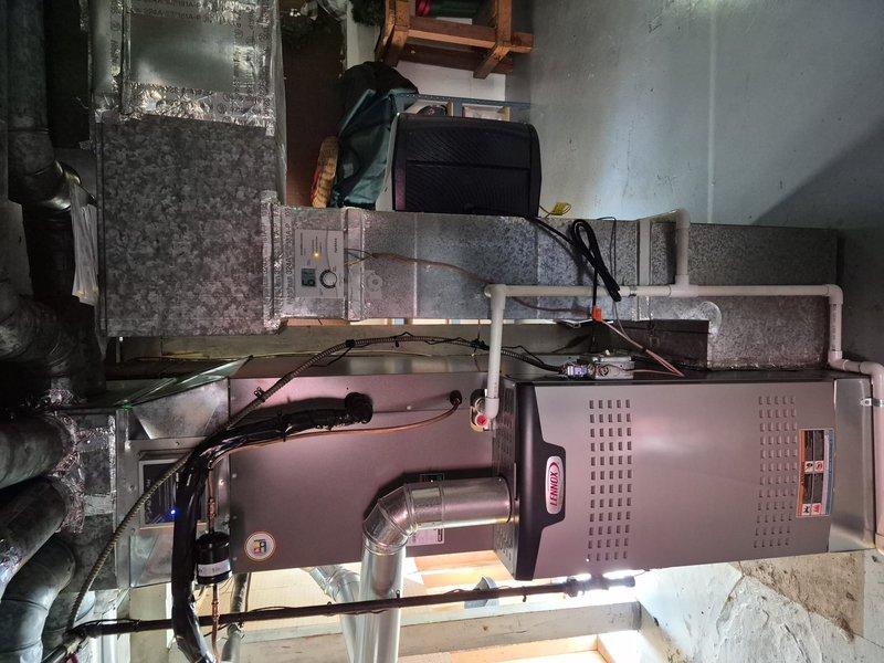 Completed annual air conditioning clean and check maintenance service per comfort plan agreement. Performed comprehensive system inspection of furnace and air handler unit located in basement mechanical room, verified electrical connections and controls, tested system operation with digital multimeter to confirm proper voltage and amperage readings, and documented equipment condition with photos for service records.