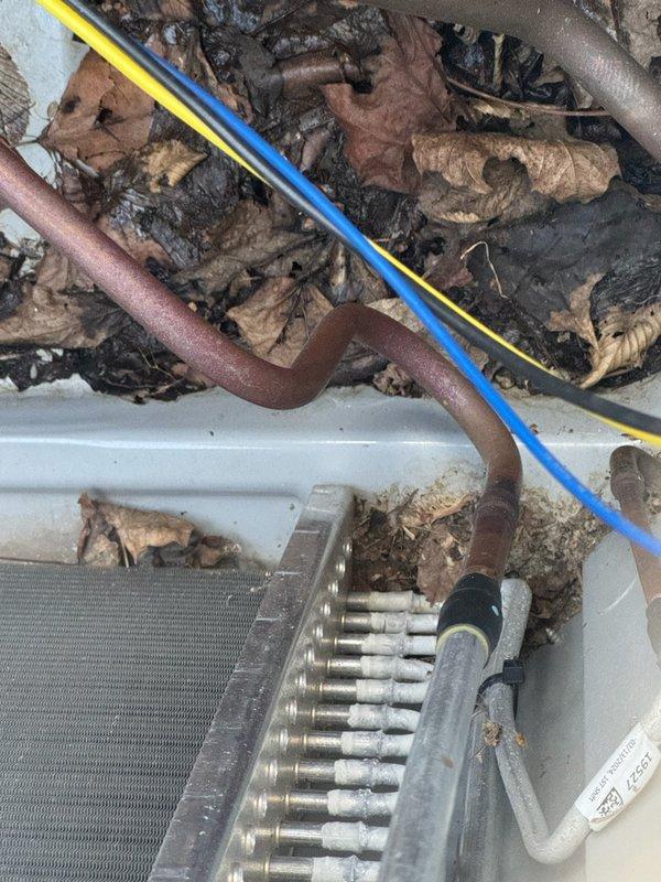 Responded to no-cool complaint on 2-year-old 2.5-ton system serving 2200 square foot residence. Upon inspection, discovered severely restricted airflow due to completely clogged air filter and significant debris accumulation including dried leaves and organic material throughout the evaporator coil and air handler cabinet. Previous contractor had misdiagnosed the issue as compressor failure requiring hard start kit without performing basic maintenance checks. Removed and cleaned extensive debris from evaporator coil housing and surrounding areas. Replaced heavily soiled air filter with proper specification filter. Verified all electrical connections, refrigerant pressures, and system operation. System restored to proper cooling operation with adequate airflow and temperature differential across coil. Discussed proper filter maintenance schedule and recommended follow-up coil cleaning to address remaining buildup on evaporator fins.