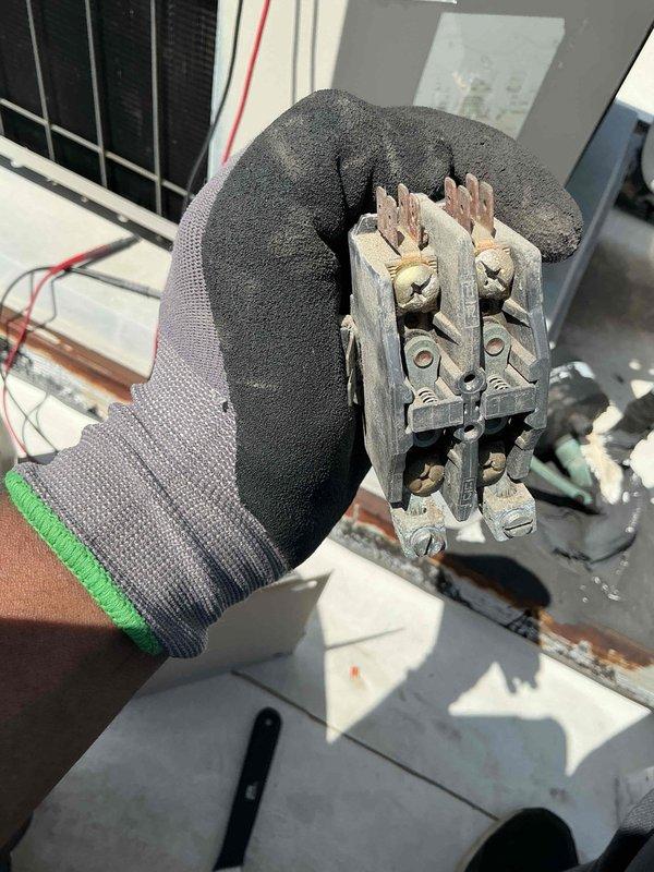 Responded to no cooling complaint at commercial office space. Upon inspection, discovered failed contactor with severely burnt and corroded contact points showing evidence of electrical arcing and thermal damage. Removed defective contactor and replaced with new unit. Verified proper electrical connections, tested system operation, and confirmed cooling restored to affected space.