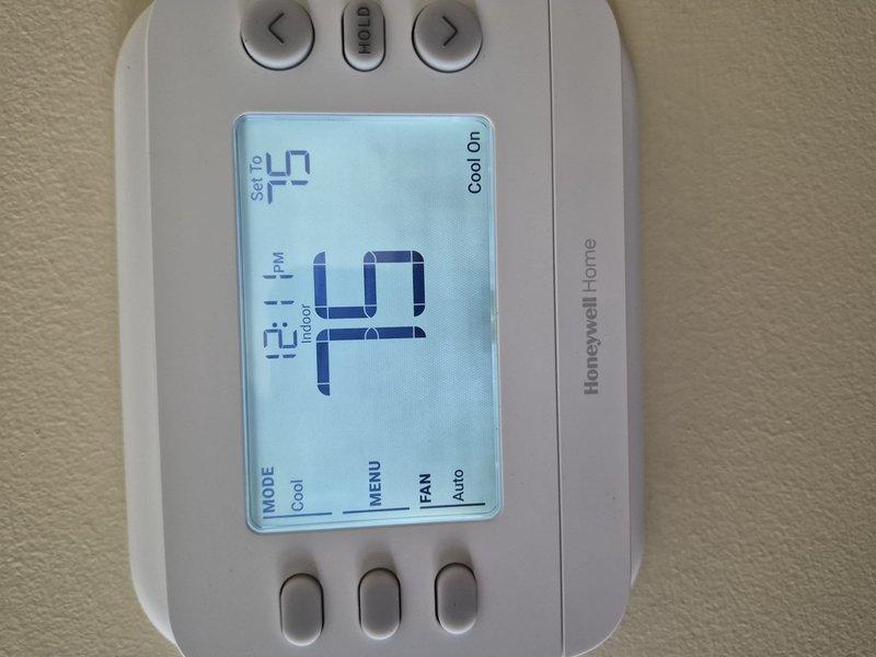 Completed preventive maintenance clean and check on single cooling system. Verified thermostat operation with Honeywell Home unit displaying proper cooling mode functionality at 64°F ambient with setpoint of 51°F. Performed electrical diagnostics using True RMS multimeter to verify system amperage and voltage readings within manufacturer specifications.