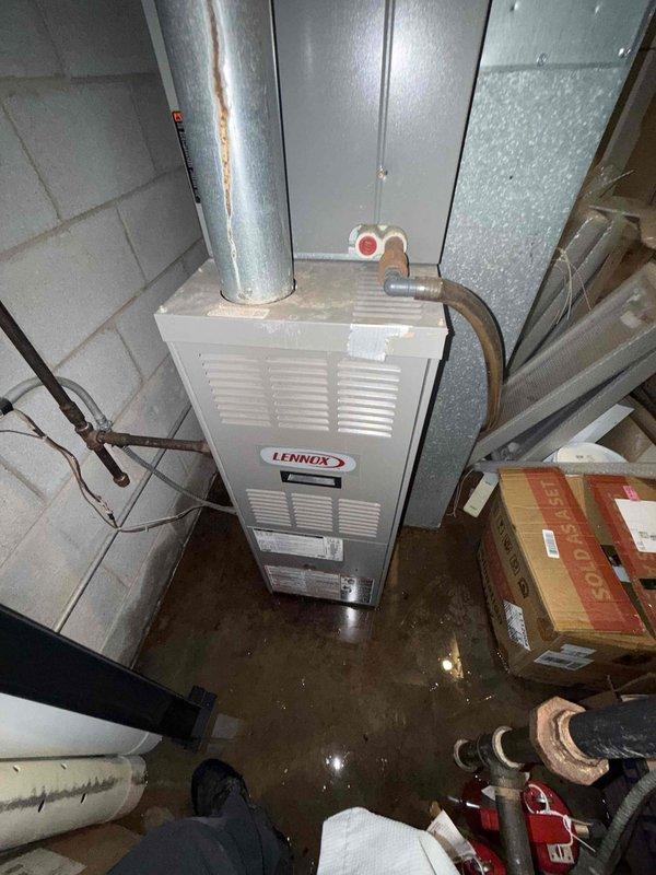Responded to commercial service call for front office air conditioning not working. Upon arrival, inspected Lennox HVAC system in basement mechanical room. Found significant water pooling on concrete floor throughout utility area, indicating potential condensate drain issue or equipment malfunction affecting system operation. Evaluated furnace unit, ductwork connections, copper refrigerant lines, and air handler components. Noted rust staining on vertical galvanized ductwork and oxidation on copper piping consistent with moisture exposure. Inspected gas valve assembly, electrical connections, and related mechanical components. System assessed under prepaid commercial service agreement maintenance visit.
