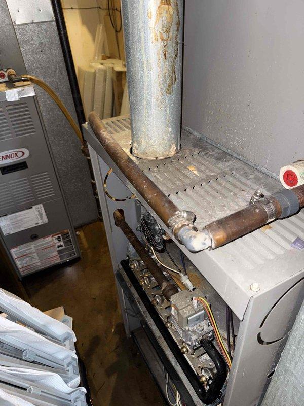 Responded to commercial service call for front office air conditioning not working. Upon arrival, inspected Lennox HVAC system in basement mechanical room. Found significant water pooling on concrete floor throughout utility area, indicating potential condensate drain issue or equipment malfunction affecting system operation. Evaluated furnace unit, ductwork connections, copper refrigerant lines, and air handler components. Noted rust staining on vertical galvanized ductwork and oxidation on copper piping consistent with moisture exposure. Inspected gas valve assembly, electrical connections, and related mechanical components. System assessed under prepaid commercial service agreement maintenance visit.