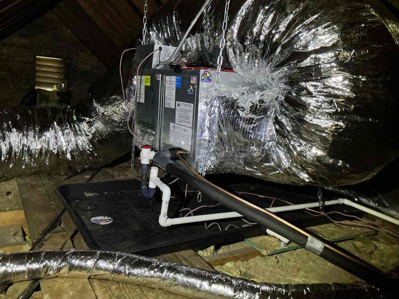 Responded to callback regarding non-operational compressor one day after completing warranty service on attic-mounted air handler system. Upon inspection, verified air handler installation including suspended unit with multiple insulated flex duct branches, condensate drain pan, and PVC drain lines. Conducted diagnostic measurements and system evaluation to determine if compressor issue was related to previous warranty work or represented a new failure requiring separate attention.