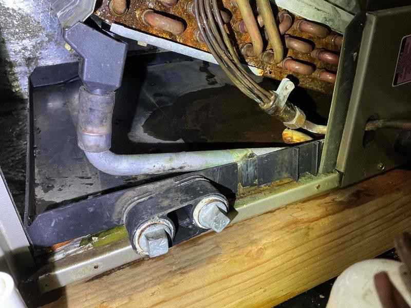 Responded to return visit for AC system with persistent refrigerant leak and complete power failure following previous repair attempt. Upon arrival, conducted comprehensive diagnostic evaluation of attic-mounted air handler and associated components. Inspection revealed significant corrosion on copper refrigerant lines and deteriorated condition of multiple system components, including compromised evaporator coil connections. System exhibited evidence of ongoing leak with moisture accumulation in drain pan area. Verified electrical connections, breaker status, and thermostat settings—unit failed to power on during initial testing. Traced power issue to damaged wiring or control board failure related to previous service work. Documented extensive rust and oxidation on refrigerant tubing, indicating prolonged exposure to moisture and potential multiple leak points. Photographed corroded copper lines, deteriorated mounting hardware, and overall system condition in attic installation. Give