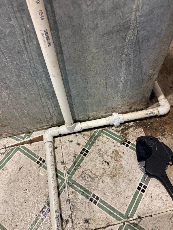Responded to service call for air conditioning unit leaking water in basement utility area. Upon inspection, found humidifier mounted on gray metal ductwork above furnace air handler with visible moisture concerns. Assessed HVAC system for potential frozen evaporator coil condition as reported cause of water leak. Examined PVC condensate drain line routing and floor area showing evidence of water accumulation on tile flooring. Documented equipment conditions including humidifier unit, ductwork assembly, and drainage system configuration. Collected standard diagnostic fee and discussed available repair options with property owner, including preventive maintenance plan enrollment and new customer discount eligibility. Recorded all equipment model and specification information from existing labels on air handler and water heater for service records.