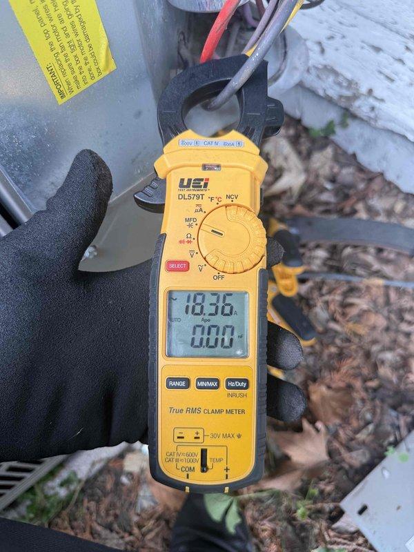 Responded to no cooling complaint on 10-15 year old residential air conditioning system. Upon arrival, performed visual inspection of outdoor condensing unit and electrical components. Accessed outdoor disconnect cabinet and observed weathered internal wiring and capacitor with signs of age-related deterioration including corrosion on cylindrical component surfaces. Utilized digital clamp meter to measure electrical parameters at the unit, obtaining amperage reading of 183.6 amps during diagnostic testing. Identified electrical issue preventing proper system operation. Documented equipment condition with photos showing internal cabinet components and diagnostic measurements. Presented repair options to restore cooling functionality.