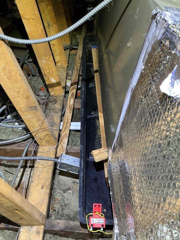 Responded to callback for condensate drain line obstruction preventing proper drainage. Upon inspection in attic space, located air handler unit and associated condensate drainage system with white PVC piping assembly. Verified drain pan was collecting water but line was not flowing properly. Cleared blockage from condensate line, tested drainage flow, and confirmed system was draining freely. Monitored unit through complete cooling cycle to ensure proper condensate removal and verified no water accumulation in drain pan.