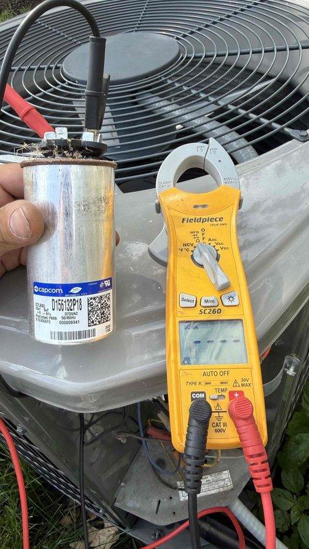 Responded to no cooling call where outdoor condensing unit was not communicating with indoor air handler. Upon inspection, diagnosed failed run capacitor (Capacom D16R1218) with visible corrosion and deterioration. Verified failure using Fieldpiece SC260 multimeter with capacitance testing. Replaced defective capacitor with proper replacement, restored power, and tested system operation. Unit now cooling properly with condenser fan operating and communication restored between outdoor and indoor units.