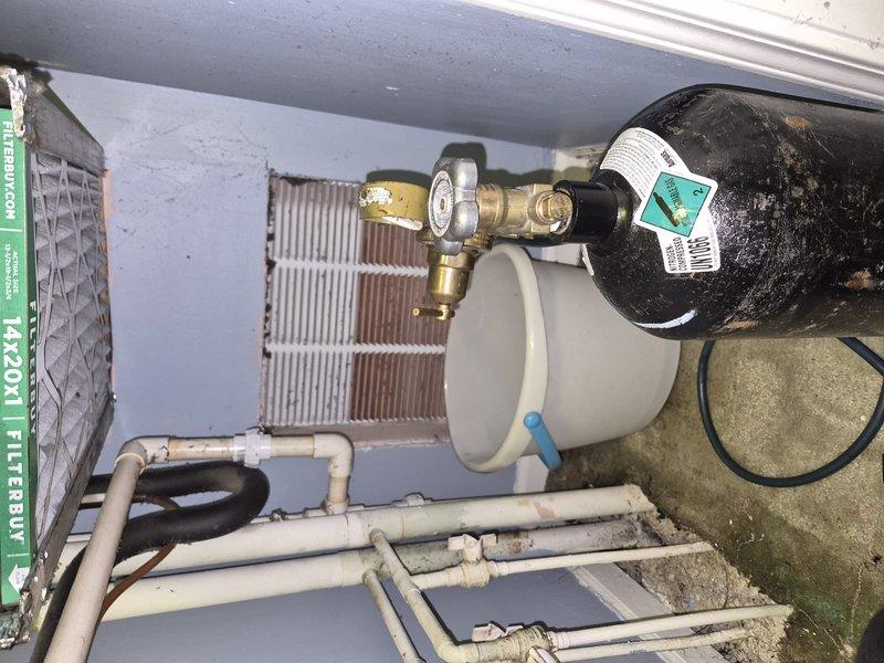 Responded to service callback for water leak issue originating from customer's unit that was initially addressed earlier in the day. Upon arrival, assessed HVAC system and outdoor equipment installation including pressure tank, valve assembly, and associated piping. Retrieved nitrogen tank and regulator from office as needed for system evaluation. Determined leak was related to building infrastructure rather than tenant equipment. Documented system conditions with photos showing outdoor HVAC components and indoor air handler installation. Building management to be billed for necessary repairs.