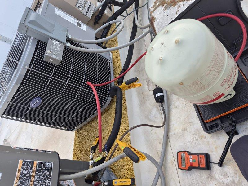 Responded to warranty call for recently installed Carrier AC unit failing to cool properly, with indoor temperature reading 81°F despite thermostat set to 70°F. Performed comprehensive diagnostic testing on the condensing unit using professional HVAC gauges and digital measurement equipment. Checked refrigerant pressures, electrical connections, and system performance parameters. Utilized vacuum recovery equipment and tested system with calibrated Vevor RES-100 measurement device to identify cooling deficiency. Traced issue to installation-related component requiring adjustment under warranty coverage. Restored proper system operation and verified unit achieving target temperature setpoint.