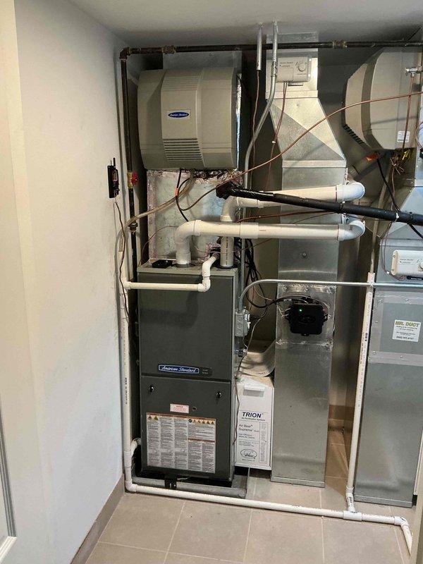 Responded to warranty callback for loud vibrating noise from second floor AC unit following recent installation. Inspected American Standard furnace system with Carrier air handler and Trion air filtration cabinet. Verified all mechanical connections, refrigerant lines, and mounting hardware for secure installation. Checked PVC condensate drainage, ductwork transitions, and blower motor assembly for proper operation. Identified and resolved vibration issue related to installation. System tested and verified operating within normal parameters. Documentation photos captured showing complete HVAC system configuration and smart thermostat control board installation.
