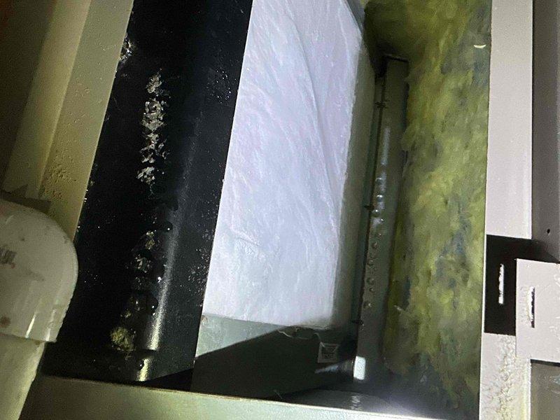 Responded to no cooling complaint with 7-degree temperature differential between thermostat setpoint and actual room temperature. Upon inspection, found Frigidaire air handler with severely contaminated evaporator coil restricting airflow and significantly reducing heat transfer capacity. Coil exhibited heavy accumulation of dust, dirt, and debris on fins and surfaces. Additionally, discovered extensive mold and algae growth in drain pan and surrounding interior compartment surfaces, indicating prolonged moisture issues and inadequate drainage. Performed thorough cleaning of evaporator coil to restore proper airflow and heat exchange efficiency. Cleaned and treated drain pan and interior surfaces to remove biological growth. Cleared condensate drain line to ensure proper moisture removal. Verified system operation after service; unit now cooling effectively with improved airflow and temperature control restored to normal parameters.