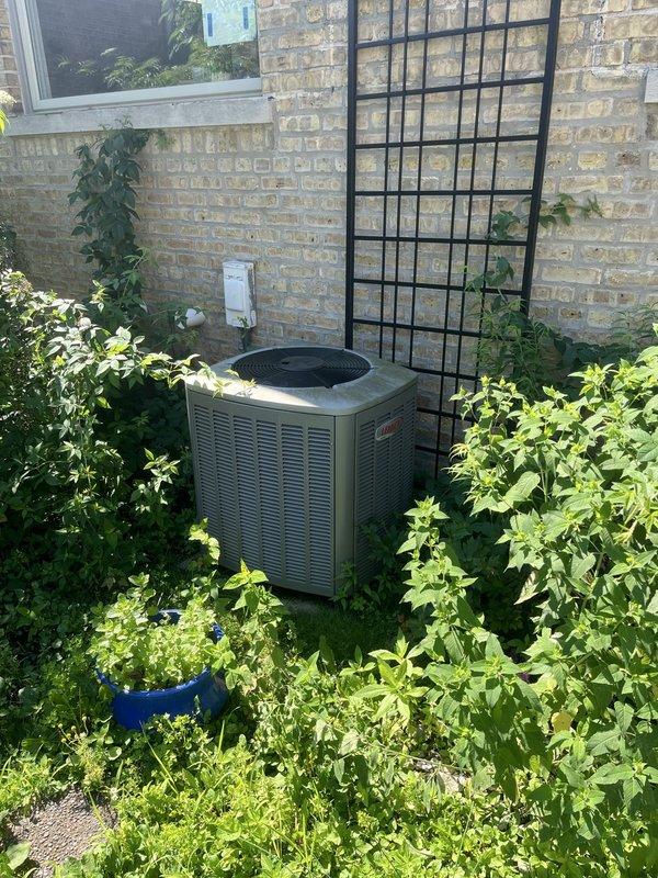 Conducted site evaluation for complete HVAC system replacement estimate on approximately 15-year-old equipment. Customer reported furnace producing whining noise and air conditioning condenser with unbalanced fan operation. Assessed outdoor condensing unit positioned on concrete pad against exterior brick wall and inspected indoor air handler/furnace system located in basement mechanical room, documenting existing equipment specifications and installation configuration for replacement proposal.