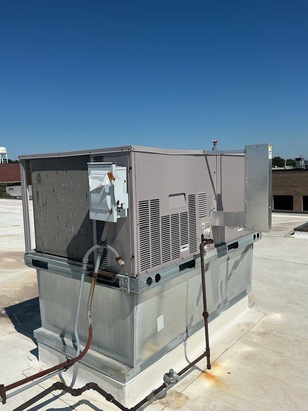 Responded to no cooling complaint for commercial office space. Upon arrival, found rooftop packaged HVAC unit with severely damaged electrical disconnect box. Disconnect cover was deteriorated with metal sections torn away, exposing internal components and creating safety hazard. Heavy rust observed on locking mechanism and mounting hardware. Inspected unit operation and refrigerant lines, which appeared intact. Documented equipment condition with photographs showing extent of disconnect box damage and overall unit status. Customer advised that comprehensive no cooling diagnostic was completed within past month. Collected continuation time for ongoing service issue related to inadequate cooling performance in office area.