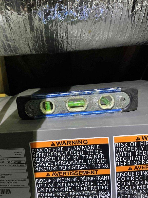 Returned to newly installed air conditioning system to investigate reported water leakage concerns from previous visit. Inspected drain pan for cracks and examined PVC condensate drain line for proper installation and functionality. Verified system levelness using precision level tool on air handler unit, checked drain pan integrity, and confirmed condensate drainage pathway was clear and functioning properly. Documented equipment condition and installation quality with photographic evidence showing HVAC unit, ductwork, insulation, and filtration components in attic space.