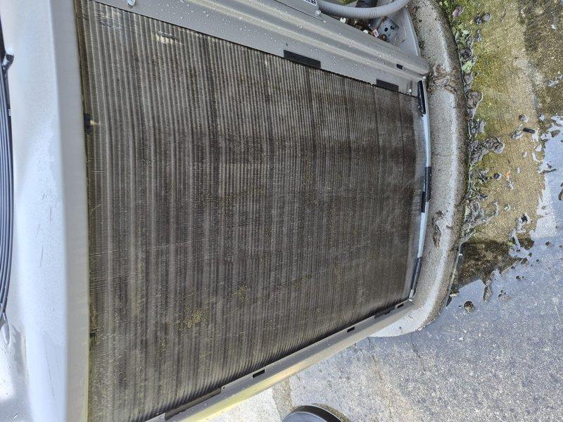 Completed preventative maintenance clean and check on single HVAC system per comfort plan agreement. Inspected outdoor condenser unit, noting moderate dirt and debris accumulation on coil fins with visible streaking patterns. Performed electrical diagnostics using digital multimeter, recording microamp DC readings to verify system performance and component integrity. Unit operational upon completion of service visit.