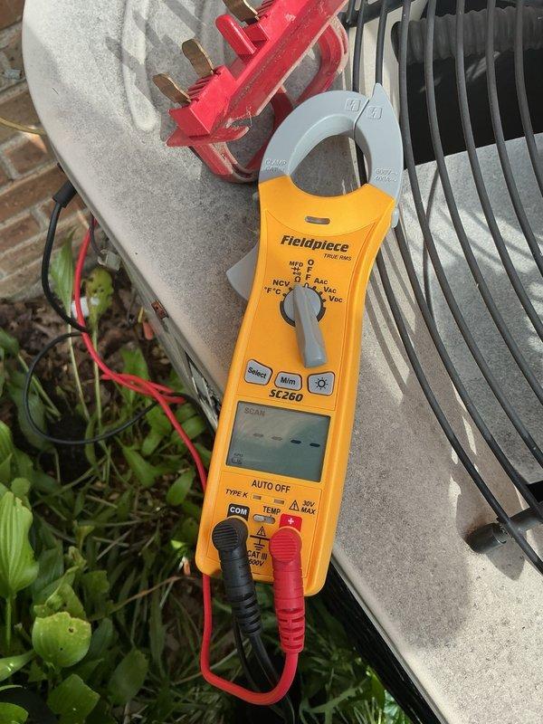 Responded to no-cooling complaint on residential air conditioning system. Upon arrival, found outdoor condenser unit with humming compressor that was not engaging properly. Conducted electrical diagnostics using clamp meter to verify amperage draw and confirm compressor motor failure. Condenser fan motor required manual assistance to start, indicating failed start capacitor or motor bearing failure. Unit showed minimal cooling output despite compressor operation. Diagnosed failed compressor start capacitor as primary issue preventing proper system startup. Cleared excessive vegetation growth around condenser unit that was restricting airflow and contributing to reduced efficiency. Presented repair options for capacitor replacement and recommended evaluation of compressor condition due to age of system and hard-start symptoms.