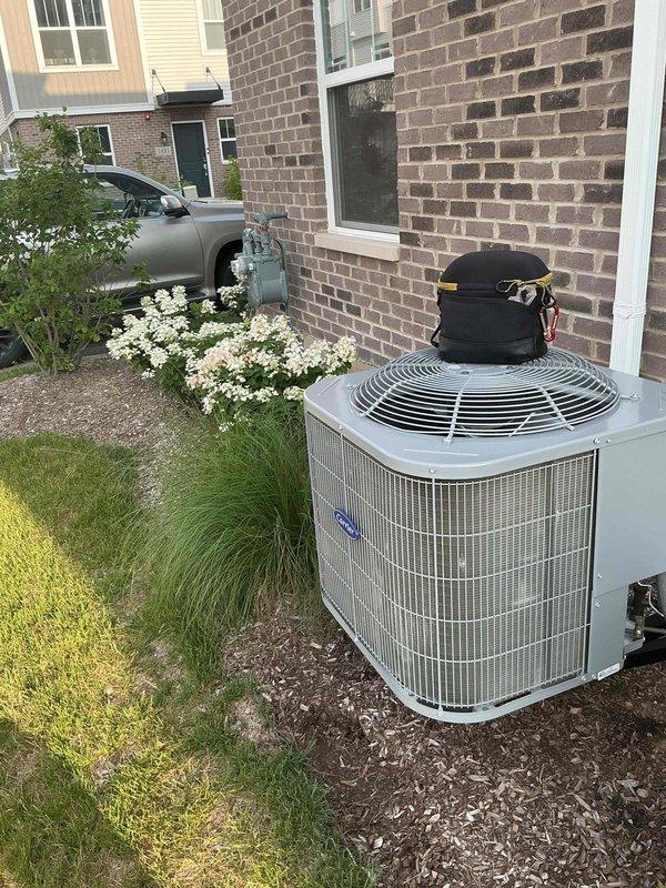 Responded to service call for excessive condensation on 2-year-old residential air conditioning system. Upon arrival, performed visual inspection of outdoor condensing unit and indoor HVAC components including furnace and associated refrigerant lines. Evaluated insulation integrity on copper refrigerant tubing, checked for proper drainage from condensate system, and inspected all accessible ductwork and piping connections. Documented system configuration with photographs showing both indoor air handler installation with PVC condensate drain lines and outdoor condensing unit positioned on concrete pad in landscaped area. Assessed overall system operation and provided customer with findings regarding condensation concerns.