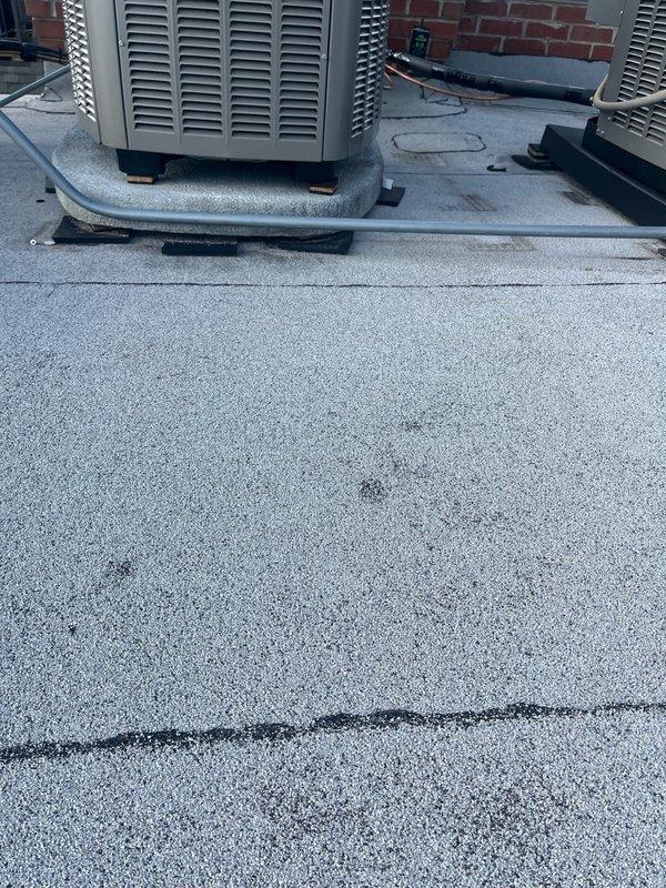 Performed warranty follow-up on multi-unit rooftop HVAC installation. Temporarily rewired thermostat control wiring by connecting R wire from wireless transmitter to Y terminal and Y to R at condenser to restore system operation pending replacement of defective wireless transmitter. Identified and documented multiple installation deficiencies requiring correction: damaged 1/2" conduit compression coupling concealed under equipment pad needs replacement, 1/2" conduit requires rerouting to prevent roof membrane contact, electrical disconnect box improperly secured with single screw instead of full mounting hardware, and 3/4" conduit serving first floor unit requires rework to eliminate roof contact. Verified all three rooftop units require programming adjustment to comfort mode per manufacturer specifications. Return visit scheduled to install new wireless transmitter, restore proper thermostat wiring configuration, replace damaged conduit coupling, secure all conduit runs with proper cl