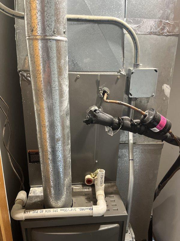 Performed comprehensive HVAC system evaluation for replacement estimate on residential property with existing 2015 furnace and 3-4 year old air conditioning system. Customer reported weak airflow throughout home despite recently replacing filter and maintaining clean evaporator coil. Conducted thorough inspection of outdoor condensing unit positioned on concrete pad adjacent to building exterior, noting cylindrical configuration with protective fan grille and standard vertical fin arrangement. Examined indoor furnace and air handler installation located in basement utility area, documenting existing ductwork configuration with galvanized metal supply plenum and associated copper refrigerant lines with insulation. Assessed overall system performance and identified need for ductwork evaluation and potential modifications to address inadequate airflow concerns. Documented equipment specifications, installation conditions, and mechanical room layout with reflective insulation barriers. Pro