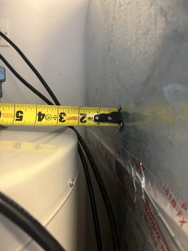 Performed water heater replacement estimate for a 75-gallon residential unit approximately 14 years old producing only lukewarm water. Inspected existing water heater installation, documented current piping configuration including copper supply lines with brass fittings and associated plumbing connections, and measured equipment dimensions for replacement planning.