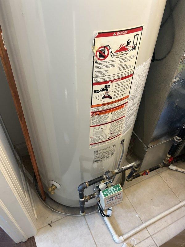 Performed water heater replacement estimate for a 75-gallon residential unit approximately 14 years old producing only lukewarm water. Inspected existing water heater installation, documented current piping configuration including copper supply lines with brass fittings and associated plumbing connections, and measured equipment dimensions for replacement planning.