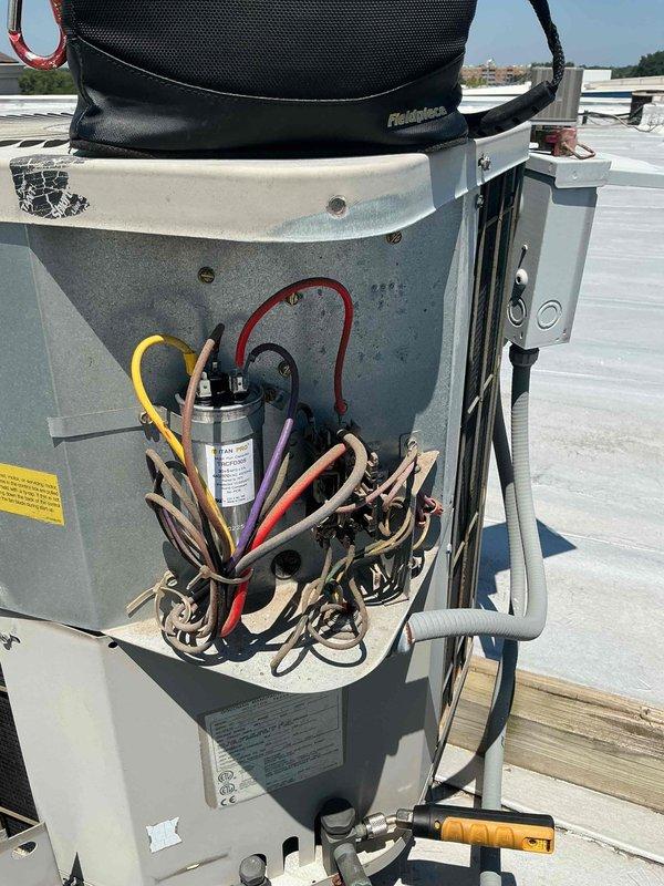 Responded to no cooling complaint on rooftop HVAC unit. Upon arrival, verified thermostat was set to cooling mode and system was calling but unit failed to operate. Performed visual inspection of outdoor condensing unit and found accessible electrical components. Removed access panel to electrical compartment and conducted diagnostic testing of starting components.

Identified failed dual run capacitor with severe corrosion and oxidation on terminals and connection points. Capacitor showed visible rust buildup and deterioration consistent with age and weather exposure on rooftop installation. Tested capacitor with multimeter and confirmed readings were out of manufacturer specifications, preventing compressor and condenser fan motor from starting properly.

Removed defective capacitor and replaced with new OEM-equivalent dual run capacitor rated to manufacturer specifications. Secured all wire connections to new capacitor terminals ensuring proper color-coded wiring configuration. Veri