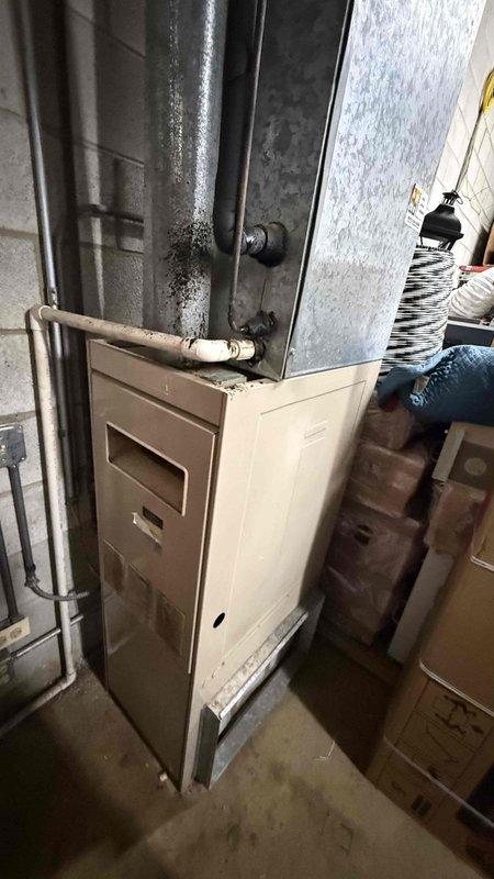 Responded to tenant report of non-functional air conditioning in unit 732 under Commercial Service Agreement. Performed system inspection of rooftop condensing units and indoor furnace equipment, documenting current conditions with photographs. Both rooftop condenser units showed signs of weathering and exterior corrosion, with refrigerant lines and mounting pads intact, while indoor furnace installation and ductwork were assessed in basement mechanical room.