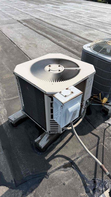 Responded to tenant report of non-functional air conditioning in unit 732 under Commercial Service Agreement. Performed system inspection of rooftop condensing units and indoor furnace equipment, documenting current conditions with photographs. Both rooftop condenser units showed signs of weathering and exterior corrosion, with refrigerant lines and mounting pads intact, while indoor furnace installation and ductwork were assessed in basement mechanical room.