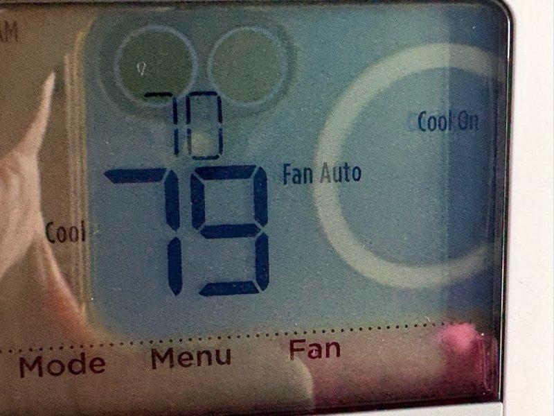 Responded to no cooling complaint with visible ice formation on refrigerant lines. Upon arrival, confirmed thermostat was set to cooling mode at 73 degrees with system running but producing warm air. Documented ice buildup on suction line tubing in closet area and photographed unit specifications and thermostat display for reference. Diagnosed restricted airflow condition causing evaporator coil to freeze, resulting in loss of cooling capacity.