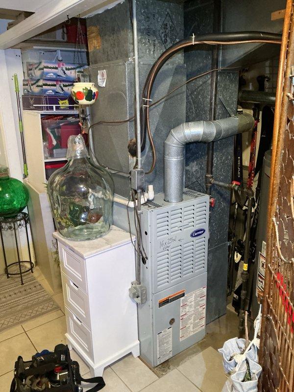 Responded to no cooling complaint with system running continuously and thermostat not reaching setpoint. Performed diagnostic evaluation of Carrier HVAC system including basement-mounted furnace with air handler and associated ductwork. Inspected refrigerant lines, electrical connections, and control wiring at both indoor units. Documented equipment information and captured photographic records of system installation and components for service file. Discussed available repair options and maintenance program benefits with customer.