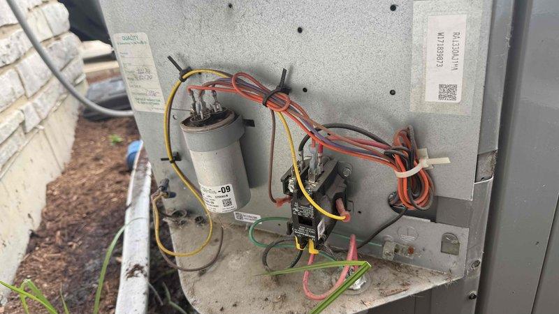 Responded to no-cool complaint on residential air conditioning system. Upon arrival, performed diagnostic inspection of outdoor condensing unit and electrical components. Inspected capacitors, contactor, and wiring connections with access panel removed. Verified thermostat settings, checked air filter condition, and confirmed breaker status. Documented equipment condition with photos of electrical components and refrigerant line connections for service records.
