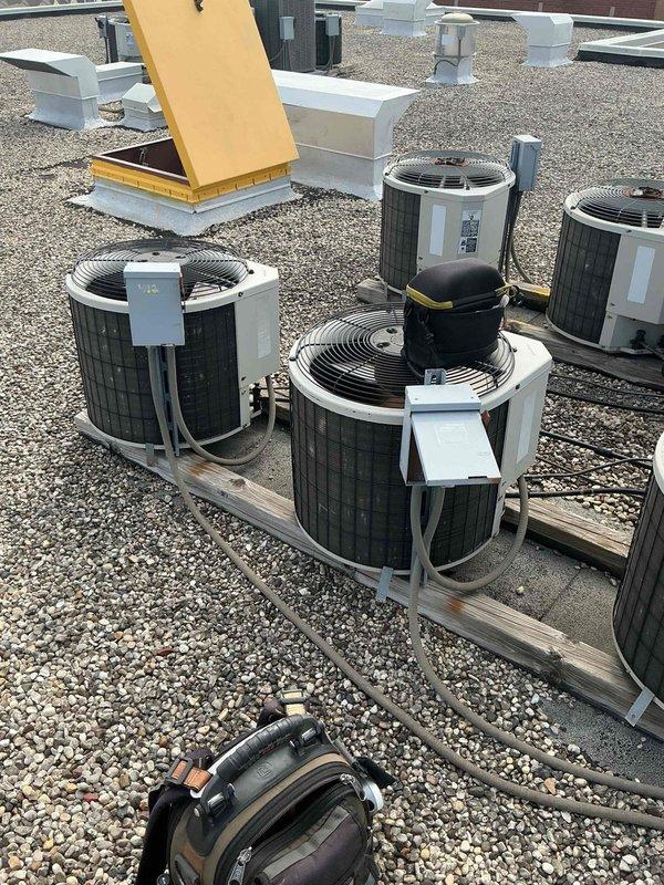Responded to service call for commercial rooftop air conditioning unit producing loud mechanical noises described as "bowling balls" inside the system. Upon arrival, conducted visual inspection of multiple rooftop condenser units and identified significant frost and ice accumulation on evaporator coil, indicating restricted airflow or low refrigerant charge. Documented equipment condition with photographs showing crystalline ice buildup along coil edges and potential airflow obstruction. System requires further diagnostic testing to determine root cause of noise complaint and address refrigerant system abnormalities affecting cooling performance.