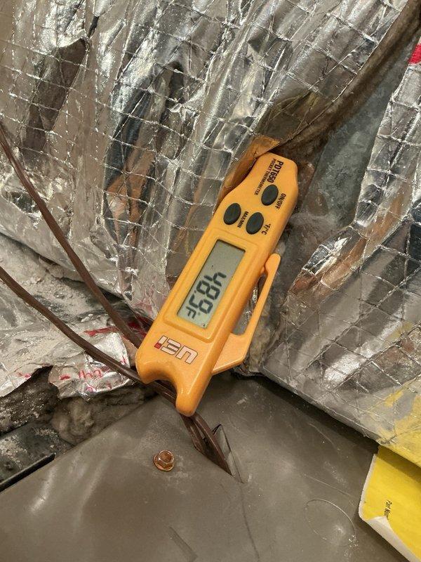 Responded to no-cooling call on 6-9 year old HVAC system with suspected capacitor issue. Upon arrival, performed diagnostic assessment of cooling equipment including temperature measurements at supply ductwork, which indicated inadequate airflow and temperature differential. Inspection of blower assembly revealed significant dust and debris accumulation on squirrel cage fan wheel and interior housing components, restricting airflow and reducing system efficiency. Documented equipment condition with thermal readings showing supply air temperature of 96.8°F, confirming insufficient cooling performance. Presented findings to customer regarding blower contamination and its impact on system operation, along with repair options to restore proper cooling function.