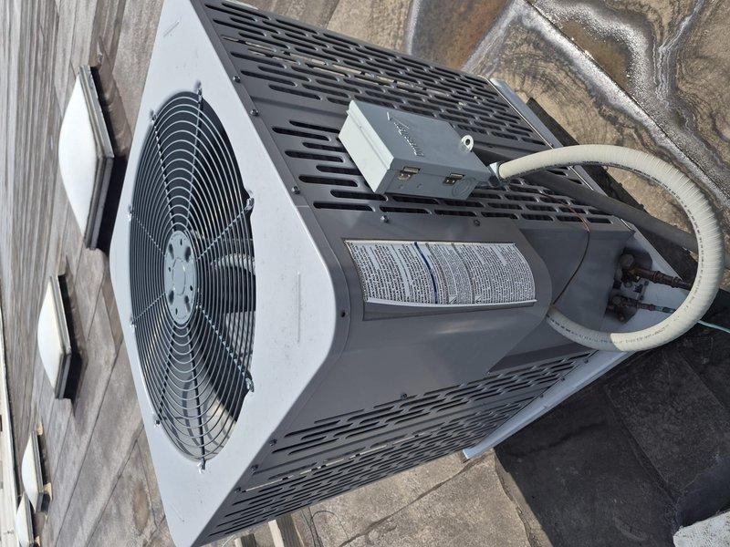 Responded to no cooling complaint at commercial facility under CSA coverage. Accessed lockbox per instructions and located outdoor condensing unit on rooftop. Performed visual inspection of HVAC system including exterior condensing unit, refrigerant lines, fan assembly, and internal mechanical components. Unit appeared operational with no visible damage, deterioration, or refrigerant leaks observed. Documented equipment condition with photographs showing condensing unit, motor assembly, and ventilation components displaying normal operational wear and dust accumulation typical of regular use.