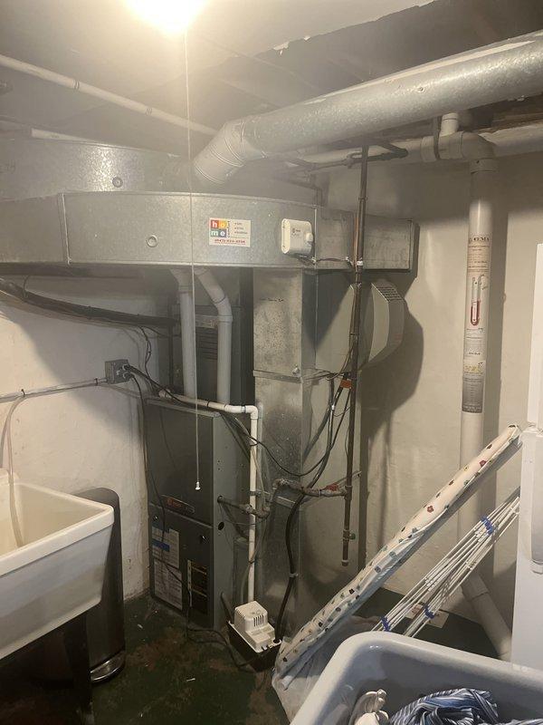 Conducted comprehensive assessment of existing Trane furnace and air conditioning system for replacement estimate in residential basement utility room. Evaluated current HVAC equipment configuration including gas furnace with PVC intake/exhaust venting, ductwork system serving multiple zones including main family room, and associated components. Documented equipment specifications, photographed existing installation layout, and assessed mechanical room space constraints for proper replacement unit sizing and installation planning.